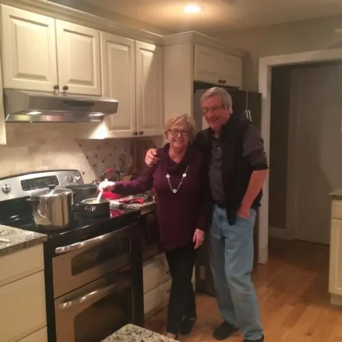 Jim poses with his wife in the kitchen at Thanksgiving