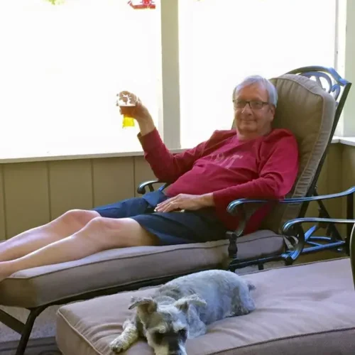 Jim relaxing in a lawn chair with a glass of beer