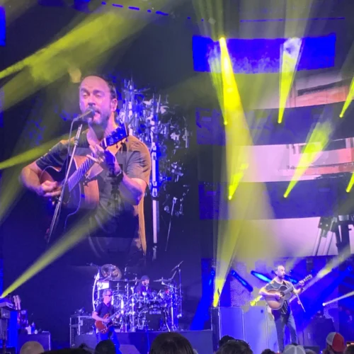 Dave Matthews Band performing live on stage, surrounded by yellow and blue stage lights