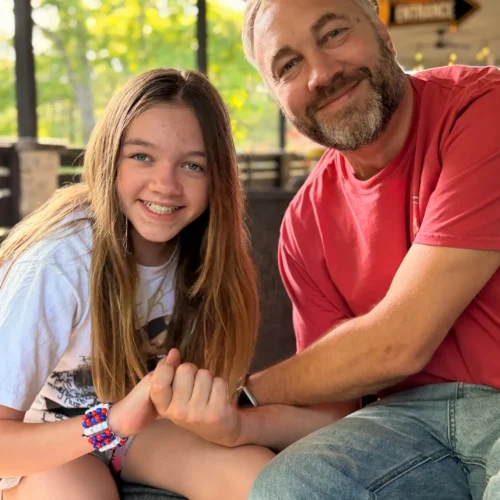 Sarah's husband and daughter smile for a photo