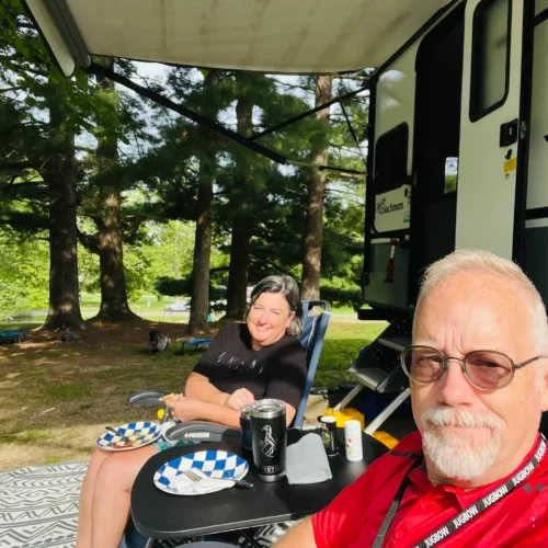 Carrie relaxes in front of an RV with her husband