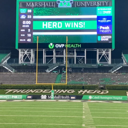 The Marshall University football stadium billboard, displaying "Herd Wins!"