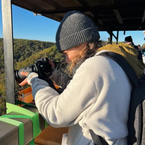 Sarah capturing action shots at Bridge Day. She stands directly beneath the raised platform that base jumpers leap from during the event