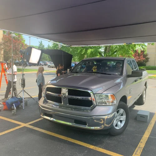 The full production setup of a Governor's Highway safety shoot. Abbey & Sarah speak to the actors that are seated inside of a large truck, preparing for a scene