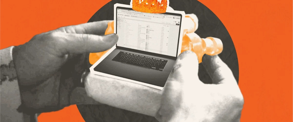 Hands holding a small laptop with a crown on it, against an orange background.