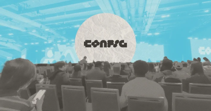 Audience seated at a conference venue with "Config" logo displayed on a large screen at the front.