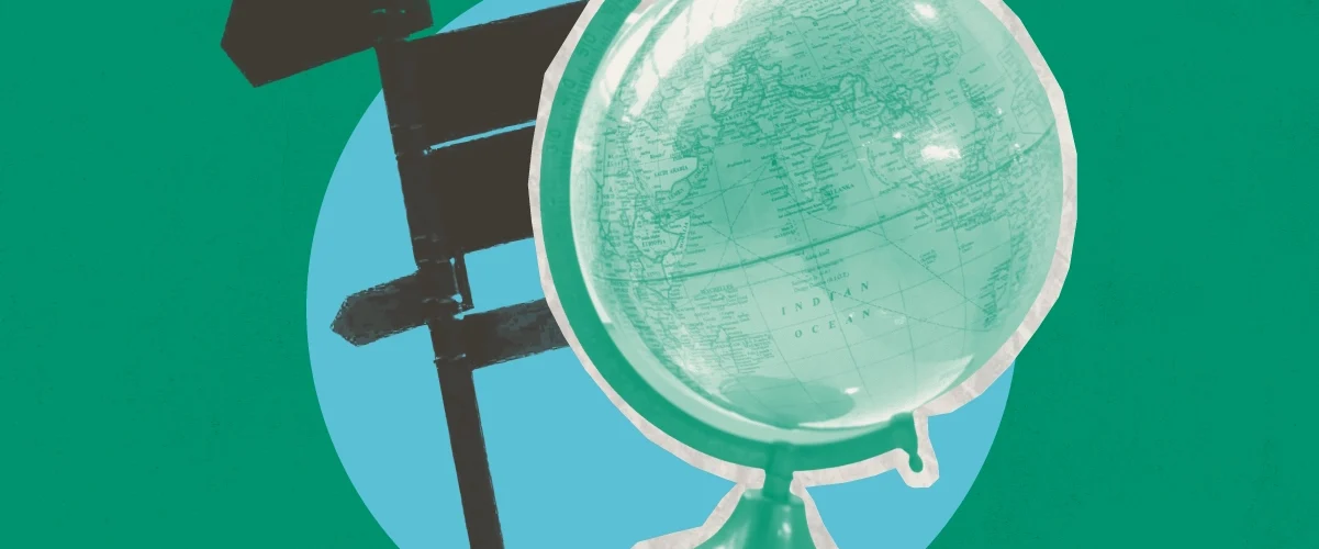 A globe and road sign on blue circle against a green background