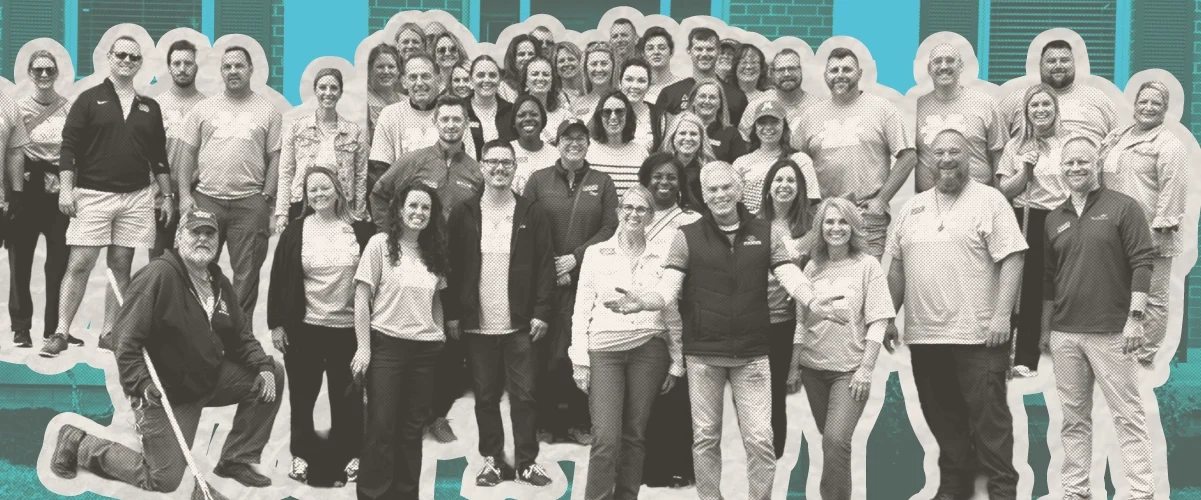 Large group of people posing together outdoors in front of a building, black and white photo with teal background.