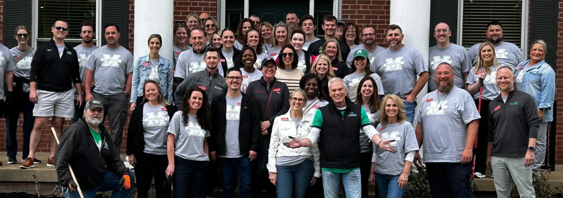 Leadership WV Class of 2025 group photo in front of a brick Welcome Center building, many wearing matching grey t-shirts with the Marshall University logo.