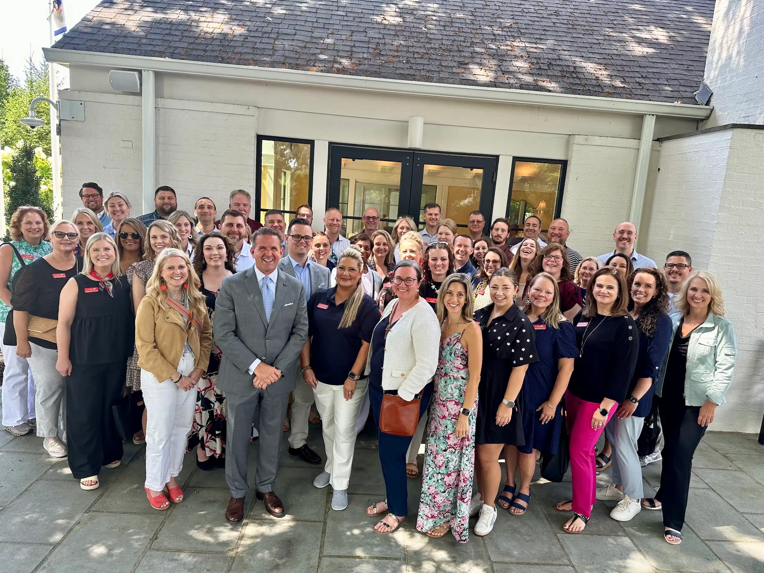 Leadership WV Class of 2025 group photo outside a white building on a sunny day.