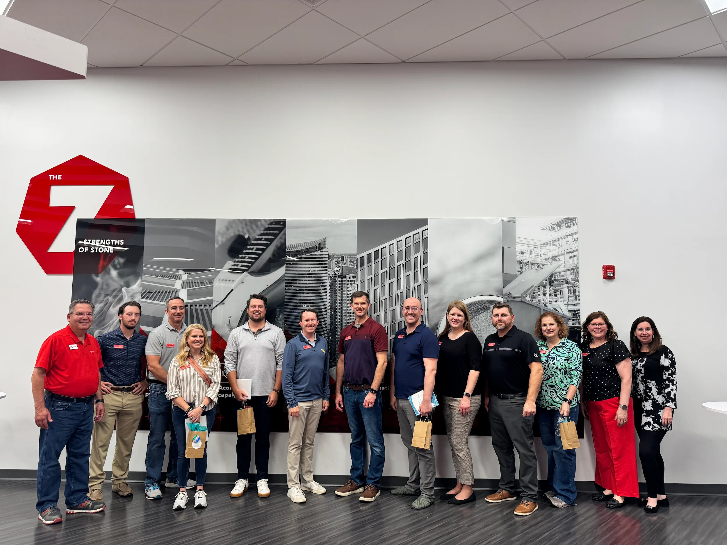 Leadership WV Class of 2025 members standing in front of a wall display featuring "The 7 Strengths of Stone" logo and images.