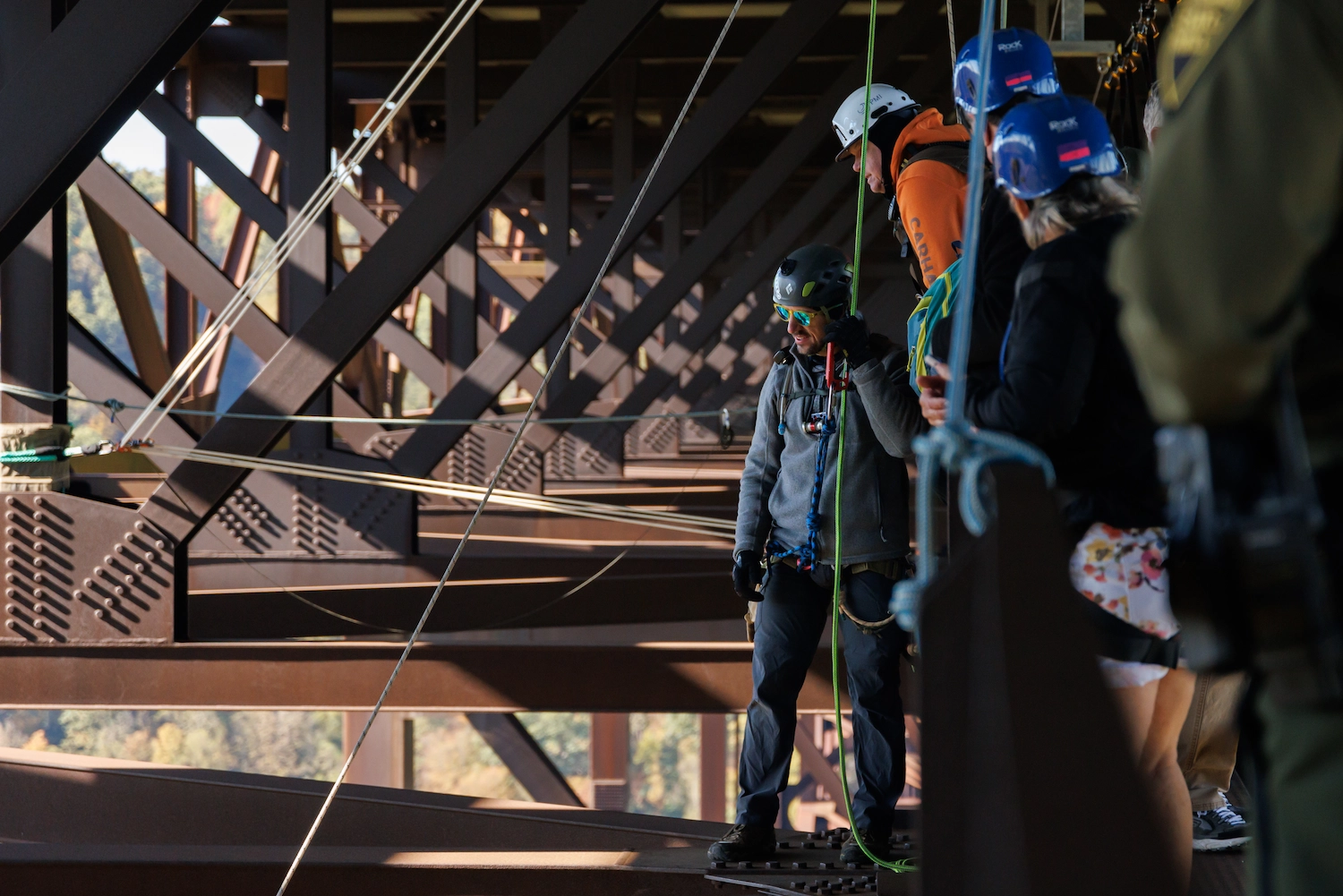 Aerial view of a BASE jumper leaping from a cliff above a river gorge surrounded by autumn foliage, parachute deploying.