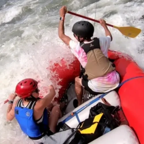Hannah and her husband Aaron maneuver a bright red raft while white water rafting