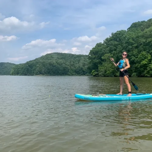 Hannah on a bright blue stand up paddle board