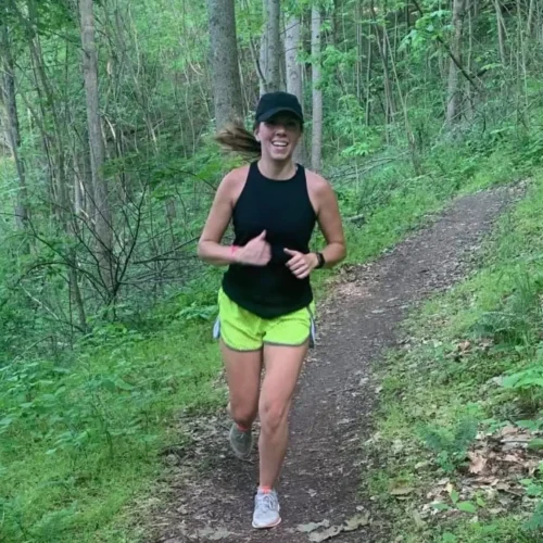 Hannah running along a trail in bright athletic clothing