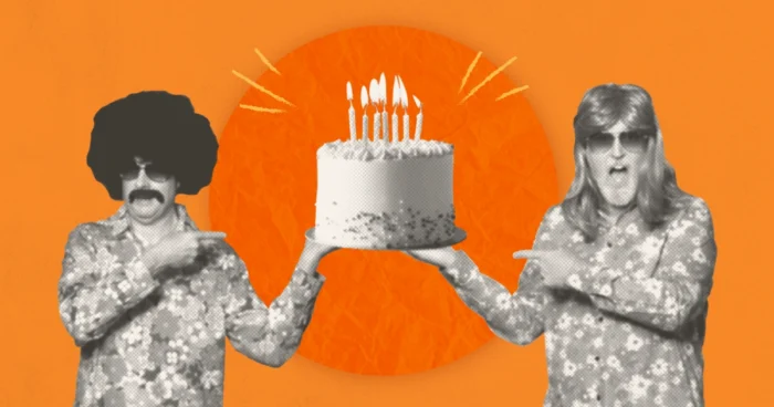 GoMart's Groovy Guys in retro 70s wigs, sunglasses and floral shirts hold a lit birthday cake against an orange background