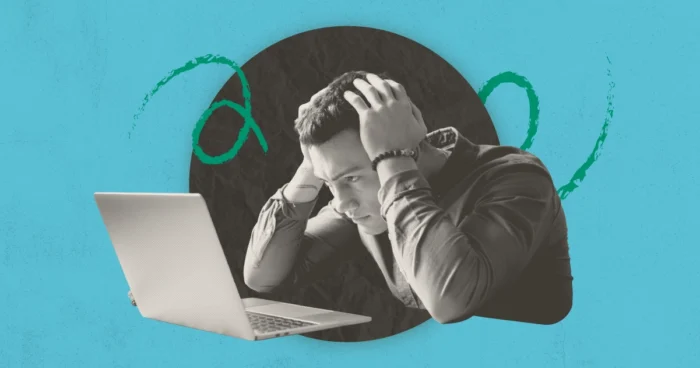 A stressed man holding his head while looking at a laptop, set against a teal background with green squiggles.